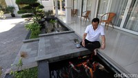 Ia terlihat asyik memberi makan ikna-ikan peliharaannya. 