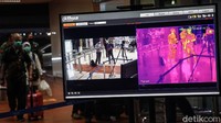 Para calon penumpang melewati alat pemindai suhu tubuh (thermal scanner) di Terminal 2 Bandara Soekarno-Hatta, Tangerang, Banten, Kamis (30/7/2020).
