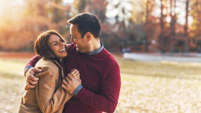 Couple in love hugging and enjoying at public park in autumn