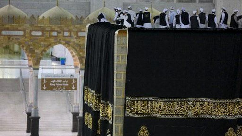 Saudi labourers put the new Kiswa, the protective cover that engulfs the Kaaba, made from black silk and gold thread and embroidered with Koran verses, on July 29, 2020 in Saudi Arabias holy city of Mecca. - The drape which engulfs the Kaaba is formally called Kiswa and is changed every year at the culmination of the annual hajj, or pilgrimage, when the hajjis have left Mecca to go to Arafat, the starting point of their hajj journey. (Photo by - / AFP)