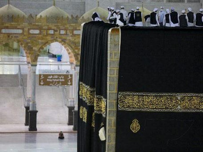 Saudi labourers put the new Kiswa, the protective cover that engulfs the Kaaba, made from black silk and gold thread and embroidered with Koran verses, on July 29, 2020 in Saudi Arabias holy city of Mecca. - The drape which engulfs the Kaaba is formally called Kiswa and is changed every year at the culmination of the annual hajj, or pilgrimage, when the hajjis have left Mecca to go to Arafat, the starting point of their hajj journey. (Photo by - / AFP)