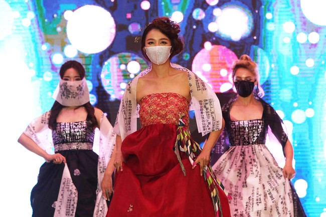 Para model tampil di 2020 Korea Mask Fashion Show dengan memakai masker. Fashion show digelar di Hotel Riverside, Seoul, Korea Selatan (24/7/2020). foto: Chung Sung-Jun/Getty Images.