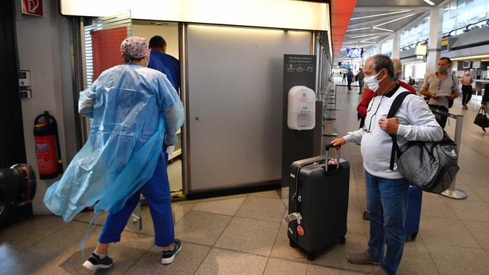 A passenger waits at a test station for the novel coronavirus that can cause the COVID-19 disease at terminal A of Berlin Tegel airport on July 29, 2020. - Germany made coronavirus tests mandatory for travellers returning from at-risk areas, as fears grow over rising case numbers blamed on summer holidays and local outbreaks. (Photo by Tobias SCHWARZ / AFP)