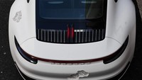 Porsche 911 Carrera 4S ini merupakan hasil karya seniman kontemporer asal Amerika, Daniel Arsham. Ia mengatakan untuk merubah tampilan itu menggunakan teknik erosi kristal. Beberapa bagian mobil dihilangkan kemudian ditempeli kristal kasar. Foto: Pool (Carscoops)