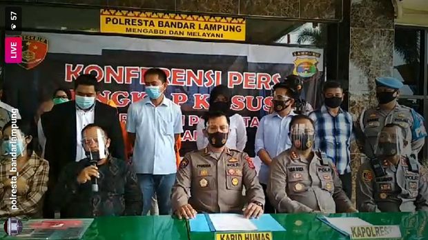 Vernita Syabilla saat rilis di Polresta Bandar Lampung, memakai kemeja cokelat kotak-kotak di samping kuasa hukumnya.