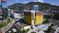 Holiday Inn di Sarajevo pertama kali membuka pintunya saat Olimpiade Musim Dingin tahun 1984. Bangunan kuning cerah yang terletak di pusat Sarajevo ini sering dibandingkan dengan balok-balok Lego dan dirancang oleh arsitek terkenal Bosnia, Ivan Straus. AP Photo/Kemal Softic  