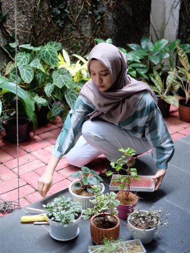 Puti Andam sedang berkebun di rumahnya