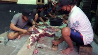 Sejumlah warga memotong daging kurban menjadi kecil-kecil kemudian dikumpulkan ke dalam wadah.