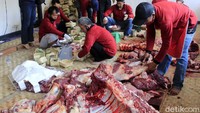 Sejumlah panitia berjibaku memotong hewan kurban menjadi beberapa bagian.