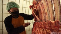 Para petugas bahu membahu melakukan pemotongan hewan kurban.