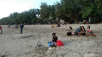 Wisatawan duduk bersantai di pasir pantai. (Angga Riza/detikcom)