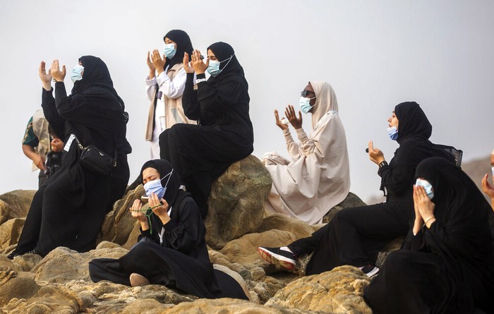 Muslim pilgrims pray on top of the rocky hill known as Mountain of Mercy on the Plain of Arafat during the annual hajj pilgrimage near the holy city of Mecca, Saudi Arabia, Thursday, July 30, 2020. Only about 1,000 pilgrims will be allowed to perform the annual hajj pilgrimage this year due to the virus pandemic. (Saudi Ministry of Media via AP)