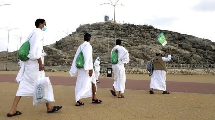 Muslim pilgrims pray on top of the rocky hill known as Mountain of Mercy on the Plain of Arafat during the annual hajj pilgrimage near the holy city of Mecca, Saudi Arabia, Thursday, July 30, 2020. Only about 1,000 pilgrims will be allowed to perform the annual hajj pilgrimage this year due to the virus pandemic. (Saudi Ministry of Media via AP)