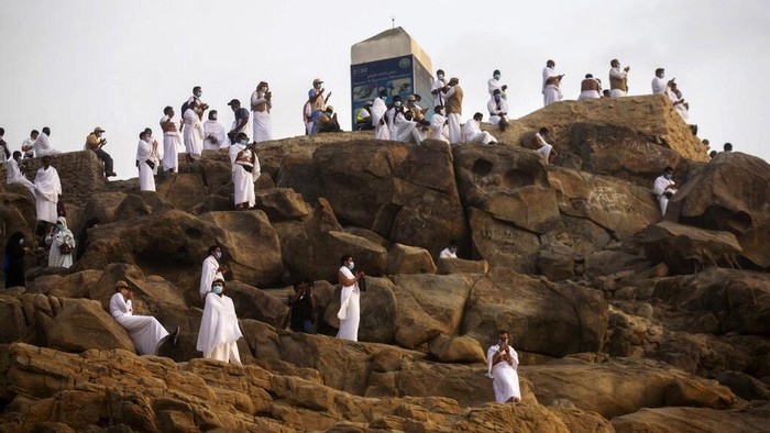 Potret Jemaah Haji Wukuf di Tengah Pandemi Muslim pilgrims pray on top of the rocky hill known as Mountain of Mercy on the Plain of Arafat during the annual hajj pilgrimage near the holy city of Mecca, Saudi Arabia, Thursday, July 30, 2020. Only about 1,000 pilgrims will be allowed to perform the annual hajj pilgrimage this year due to the virus pandemic. (Saudi Ministry of Media via AP)