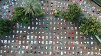 Penerapan physical distancing juga berlaku di halaman masjid. Para jemaah wajib menjaga jarak saat menunaikan salat Idul Adha.