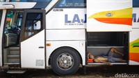 Awak bus beristirahat dengan tiduran di bagasi.
