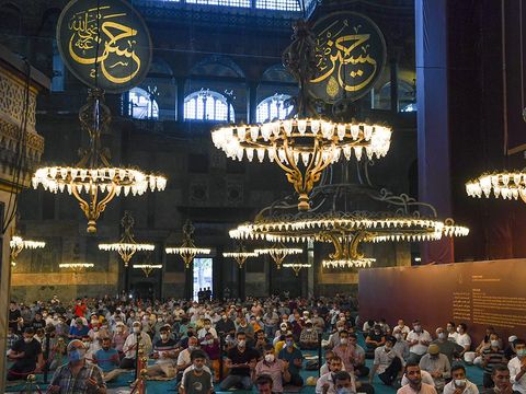 Muslims, wearing protective masks as a precaution against infection from coronavirus sit, during the Eid al-Adha prayer inside the Byzantine-era Hagia Sophia, recently converted back to a mosque, in the historic Sultanahmet district of Istanbul, Friday, July 31, 2020. Small groups of pilgrims performed one of the final rites of the Islamic hajj on Friday as Muslims worldwide marked the start of the Eid al-Adha holiday amid a global pandemic that has impacted nearly every aspect of this year’s pilgrimage and celebrations. The last days of hajj coincide with the four-day Eid al-Adha, or “Feast of Sacrifice,” in which Muslims slaughter livestock and distribute the meat to the poor.  (Pool via AP)