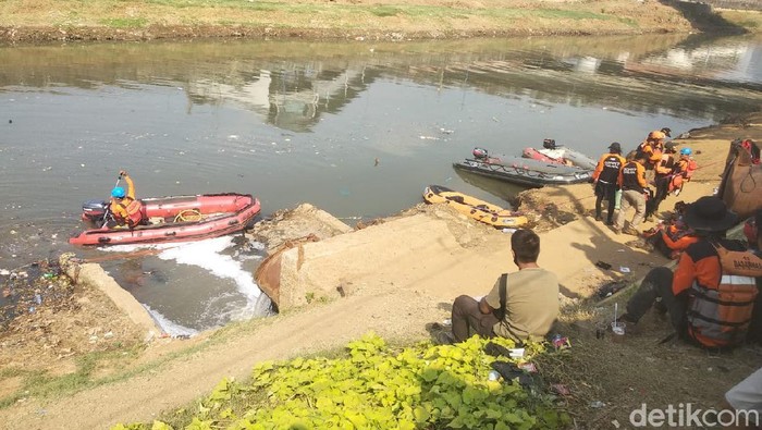 Tim SAR melakukan pencarian bocah yang tenggelam di Banjir Kanal Barat, Palmerah, Jakarta Barat