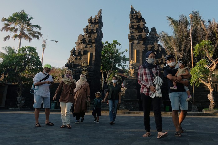 Wisatawan domestik menggunakan masker saat liburan Idul Adha 1441H di masa Adaptasi Kebiasaan Baru tahap II di obyek wisata Tanah Lot, Tabanan, Bali, Sabtu (1/8/2020). Obyek wisata tersebut mulai dikunjungi wisatawan dari luar Pulau Bali dengan menerapkan protokol kesehatan COVID-19 meskipun jumlahnya masih sedikit. ANTARA FOTO/Nyoman Hendra Wibowo/nym/wsj.