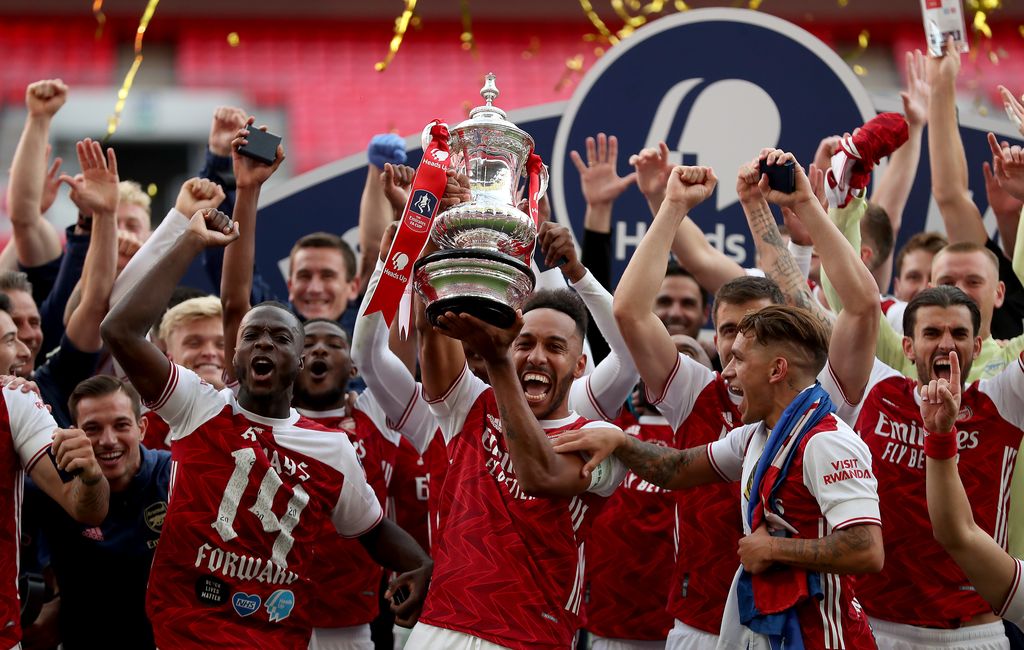 LONDON, ENGLAND - AUGUST 01: Pierre-Emerick Aubameyang of Arsenal lifts the FA Cup Trophy with his team mates after their victory in the Heads Up FA Cup Final match between Arsenal and Chelsea at Wembley Stadium on August 01, 2020 in London, England. Football Stadiums around Europe remain empty due to the Coronavirus Pandemic as Government social distancing laws prohibit fans inside venues resulting in all fixtures being played behind closed doors. (Photo by Catherine Ivill/Getty Images)