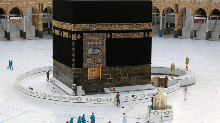 Workers clean and disinfect around the Kaaba on August 1, 2020, traced with lines for easing the physical distancing between pilgrims due to the coronavirus, during the evening before the last day of circumambulation around the shrine, in the Grand mosque of the holy Saudi city of Mecca, during the annual Muslim Hajj pilgrimage (Photo by - / AFP)