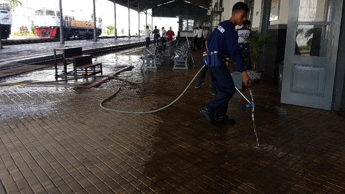 Seorang petugas membersihkan area stasiun.