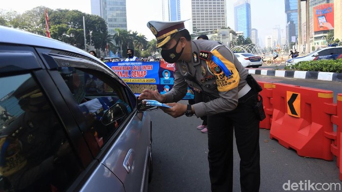 Petugas kepolisian gelar sosialisasi pelaksanaan ganjil-genap di Bundaran HI, Jakarta. Diketahui, ganjil-genap kembali diberlakukan mulai Senin (3/8) besok.
