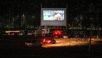 Area parkir salah satu mal di kawasan Tangerang itu kini disulap menjadi tempat pemutaran film secara drive-in. Sejumlah kendaraan roda empat pun tampak memenuhi kawasan tersebut untuk menonton film dari dalam mobil.