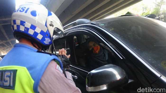 Petugas polisi sosialisasi secara langsung kepada pengemudi yang melanggar Ganjil Genap di Perempatan Rawamangun, Jalan Pramuka, Jakarta Timur, Senin (3/8/2020). Sistem ganjil kendaraan bermotor di 25 ruas jalan di DKI Jakarta kembali berlaku mulai hari ini, Senin (3/8).
