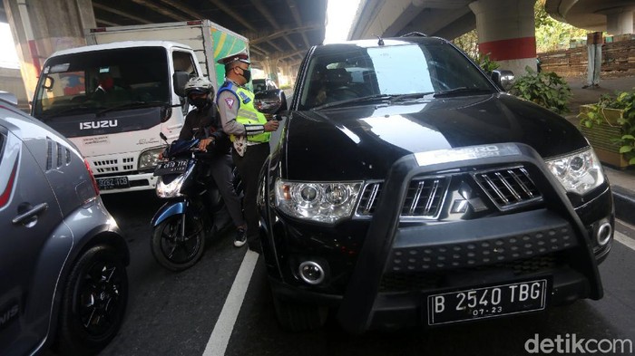 Petugas polisi sosialisasi secara langsung kepada pengemudi yang melanggar Ganjil Genap di Perempatan Rawamangun, Jalan Pramuka, Jakarta Timur, Senin (3/8/2020). Sistem ganjil kendaraan bermotor di 25 ruas jalan di DKI Jakarta kembali berlaku mulai hari ini, Senin (3/8).