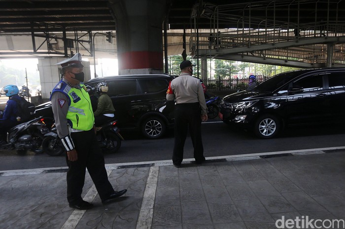 Petugas polisi sosialisasi secara langsung kepada pengemudi yang melanggar Ganjil Genap di Perempatan Rawamangun, Jalan Pramuka, Jakarta Timur, Senin (3/8/2020). Sistem ganjil kendaraan bermotor di 25 ruas jalan di DKI Jakarta kembali berlaku mulai hari ini, Senin (3/8).