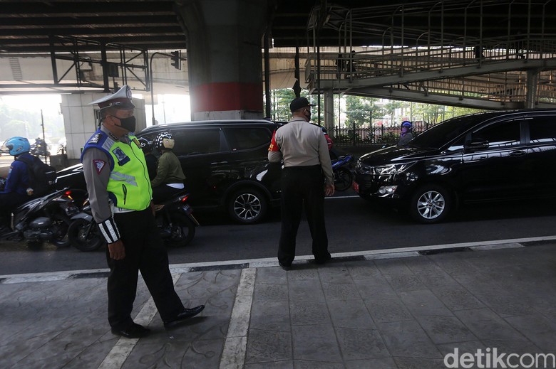 Ganjil Genap Berlaku Lagi Petugas polisi sosialisasi secara langsung kepada pengemudi yang melanggar Ganjil Genap di Perempatan Rawamangun, Jalan Pramuka, Jakarta Timur, Senin (3/8/2020). Sistem ganjil kendaraan bermotor di 25 ruas jalan di DKI Jakarta kembali berlaku mulai hari ini, Senin (3/8).