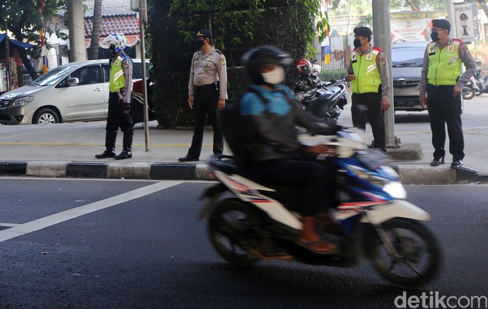 Petugas polisi sosialisasi secara langsung kepada pengemudi yang melanggar Ganjil Genap di Perempatan Rawamangun, Jalan Pramuka, Jakarta Timur, Senin (3/8/2020). Sistem ganjil kendaraan bermotor di 25 ruas jalan di DKI Jakarta kembali berlaku mulai hari ini, Senin (3/8).
