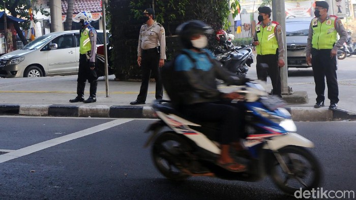 Ganjil Genap Berlaku Lagi Petugas polisi sosialisasi secara langsung kepada pengemudi yang melanggar Ganjil Genap di Perempatan Rawamangun, Jalan Pramuka, Jakarta Timur, Senin (3/8/2020). Sistem ganjil kendaraan bermotor di 25 ruas jalan di DKI Jakarta kembali berlaku mulai hari ini, Senin (3/8).