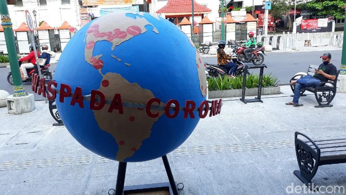 Properti peringatan waspada virus Corona atau COVID-19 di Titik Nol Kilometer Yogyakarta.