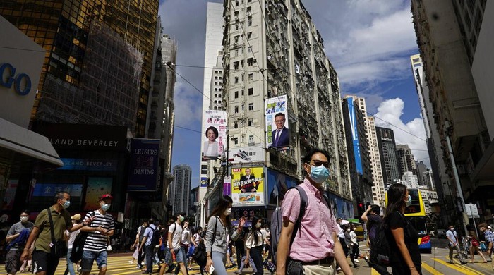 People wearing face masks walk by an electronic stock board of a securities firm in Tokyo, Monday, Aug. 3, 2020. Asian shares were mixed on Monday, as investors watched surging numbers of new coronavirus cases in the region, including in Japan. (AP Photo/Koji Sasahara)