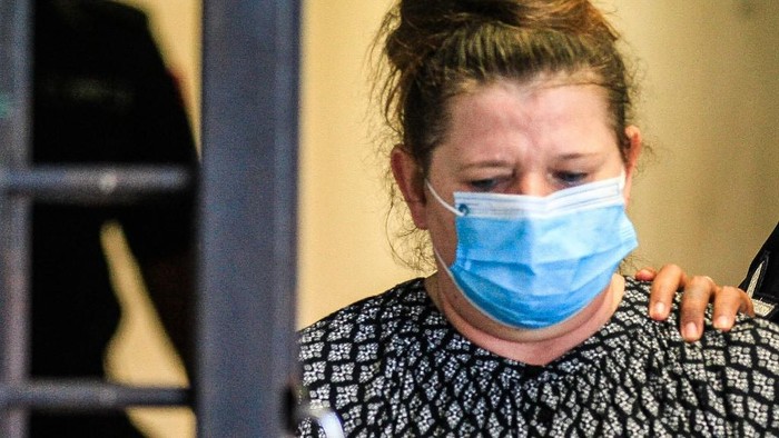 British national Samantha Jones, accused of killing her husband in 2018, is escorted by a police officer to a van after appearing in court in Alor Setar, in northern Malaysia, on August 3, 2020. - A British woman was jailed for three and a half years on August 3, after tearfully admitting she stabbed her husband to death during a fight on the Malaysian holiday island of Langkawi. (Photo by A. Ammarudin / AFP)