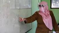 Selain siswa, guru pun juga wajib memakai masker dan face shield.