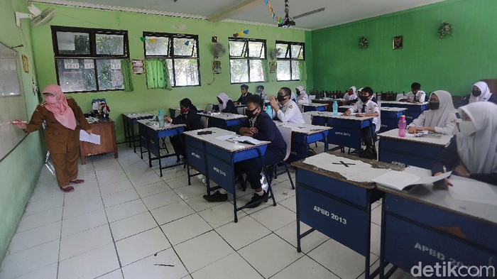 Siswa Siswi mengikuti simulasi sekolah percontohan pembelajaran tatap muka di SMP Negeri 2 Bekasi, Jawa Barat, Senin (3/8/2020). Pelaksanaan ini dilaksanakan mulai hari ini hingga 28 Agustus 2020. Siswa yang yang mengikuti pelajaran tatap muka hari ini 18 anak perkelas.  setiap kelas 7, 8 dan 9 diwakili 1 kelas yang bergantian setiap harinya.
