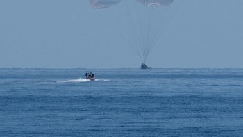 Setelah mencapai ketinggian tertentu, Crew Dragon mengerahkan serangkaian parasut untuk membantu memperlambat kecepatan sebelum pendaratan di air. Foto: NASA/Bill Ingalls