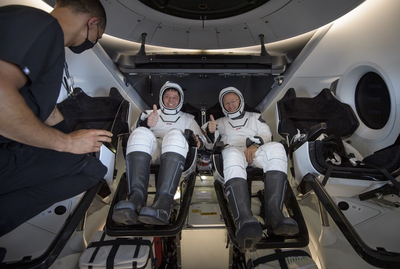 NASA astronauts Robert Behnken, left, and Douglas Hurley are seen inside the SpaceX Crew Dragon Endeavour spacecraft onboard the SpaceX GO Navigator recovery ship shortly after having landed in the Gulf of Mexico off the coast of Pensacola, Fla., Sunday, Aug. 2, 2020. The Demo-2 test flight for NASA's Commercial Crew Program was the first to deliver astronauts to the International Space Station and return them safely to Earth onboard a commercially built and operated spacecraft. Behnken and Hurley returned after spending 64 days in space. (Bill Ingalls/NASA via AP)