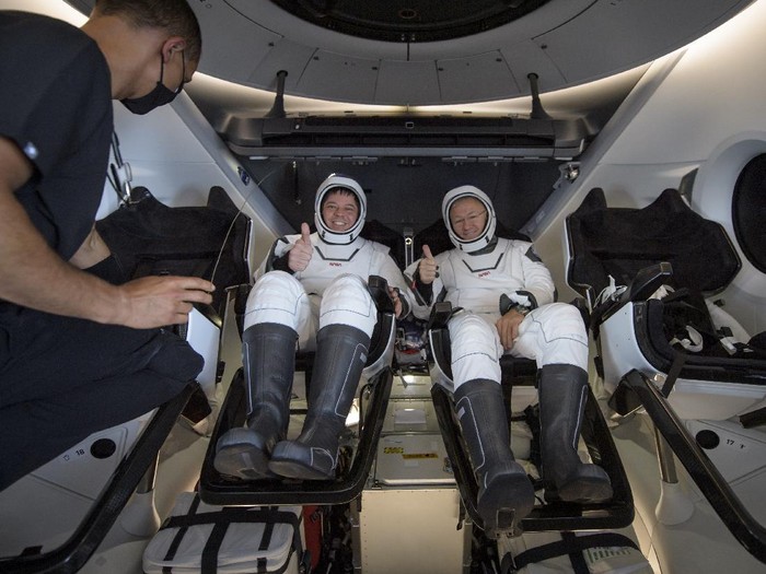 NASA astronauts Robert Behnken, left, and Douglas Hurley are seen inside the SpaceX Crew Dragon Endeavour spacecraft onboard the SpaceX GO Navigator recovery ship shortly after having landed in the Gulf of Mexico off the coast of Pensacola, Fla., Sunday, Aug. 2, 2020. The Demo-2 test flight for NASAs Commercial Crew Program was the first to deliver astronauts to the International Space Station and return them safely to Earth onboard a commercially built and operated spacecraft. Behnken and Hurley returned after spending 64 days in space. (Bill Ingalls/NASA via AP)