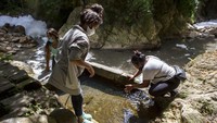 Seorang pendeta setempat menyumbang beberapa tangki plastik besar untuk masyarakat, dan kini harus mereka isi dengan membawa air minum secara teratur.  
