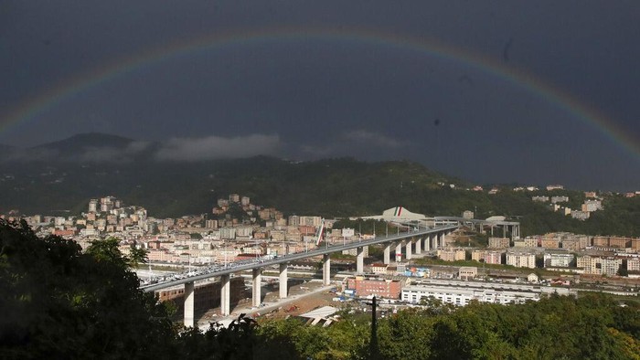 The Frecce Tricolore (Three-color Arrows) Italian Air Force aerobatic squad flies over the new San Giorgio Bridge on the occasion of its inauguration in Genoa, Italy, Monday, Aug. 3, 2020. Two years ago this month, a stretch of roadbed collapsed on Genoa's Morandi Bridge, sending cars and trucks plunging to dry riverbed below and ending 43 lives. On Monday, Italy's president journeys to Genoa for a ceremony to inaugurate a replacement bridge. (AP Photo/Antonio Calanni)
