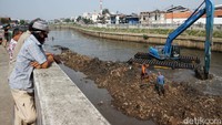 Aktivitas pengerukan lumpur menjadi tontonan warga.