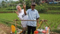 Jajan es cendol, Rachel tak lupa berpose di depan gerobak pikul dan sang penjual. Es cendolnya pasti lebih nikmat karena disantap di pinggir sawah. Foto: instagram @rachelmaryam