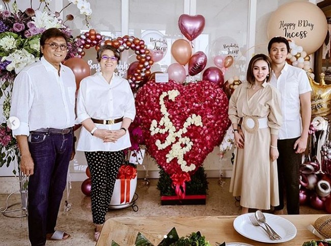 Syahrini yang setelah menikah jarang tampil di panggung memberikan potongan tumpeng ulang tahunnya pada sang ibu mertua, Reiko Barack. Tampak dalam perayaan kecil di rumah itu, ulang tahun Syahrini tetap terlihat meriah dengan berbagai dekorasi mulai dari bunga mawar dengan inisial namanya SYR dan berbagai balon berbentuk hati. Foto: Dok. Instagram @princessyahrini