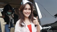 Ayu tampil dengan kemeja menerawang yang dipadukan dengan dress warna-warni. Pool/Palevi S/detikFoto.