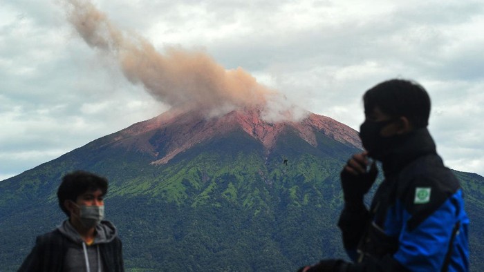 Warga mengamati suasana perkampungan saat Gunung Kerinci mengembuskan gas dan material yang terlihat dari Gunung Tujuh, Kerinci, Jambi, Rabu (5/8/2020). Pos Pengamatan Gunung Api Kerinci menyebutkan Gunung Kerinci yang statusnya masih berada pada level II (waspada) kembali mengalami gempa embusan dan tremor menerus yang terpantau secara visual dan data seismik pada Rabu (5/8) pagi. ANTARA FOTO/Wahdi Septiawan/aww.