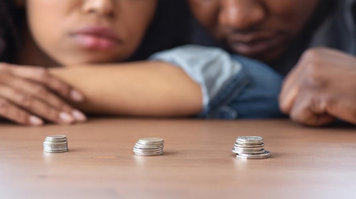 Poverty And Absence Of Money Concept. Stacks Of Coins Lying On Table In Front Of Sad African American Couple, Crop